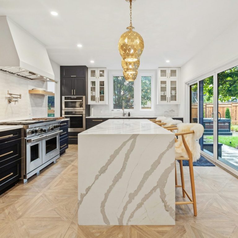 Modern kitchen with a custom marble island, dark cabinets, and beautiful tile work in North Naples.