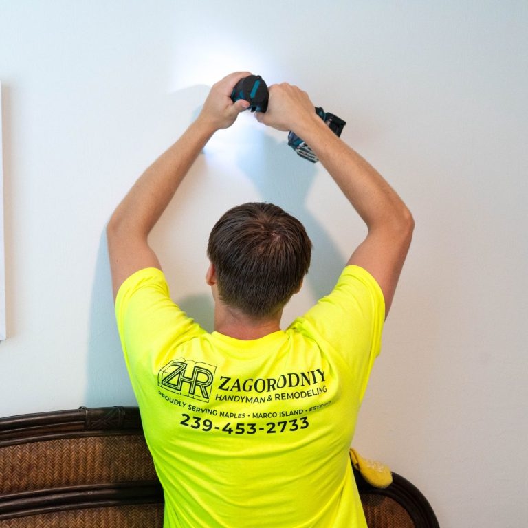 A handyman drilling into the wall of an apartment in Naples.