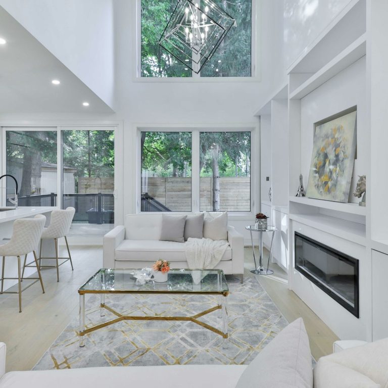 Bright, modern living room with built in shelves and fireplace, new LVP floors, and white, freshly painted walls in Naples, FL.