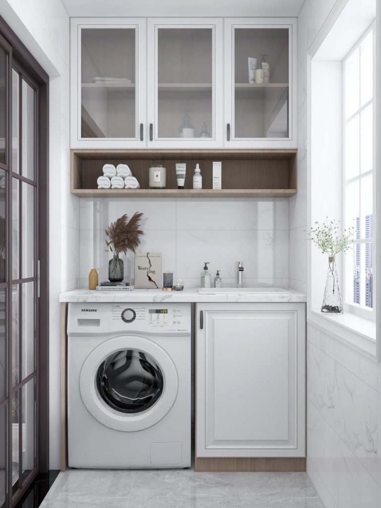 Modern laundry room with a washing machine, sink, and shelves for storage in Naples.