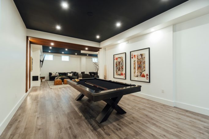 Modern game room featuring a pool table, art on the walls, and new LVP flooring in North Naples.